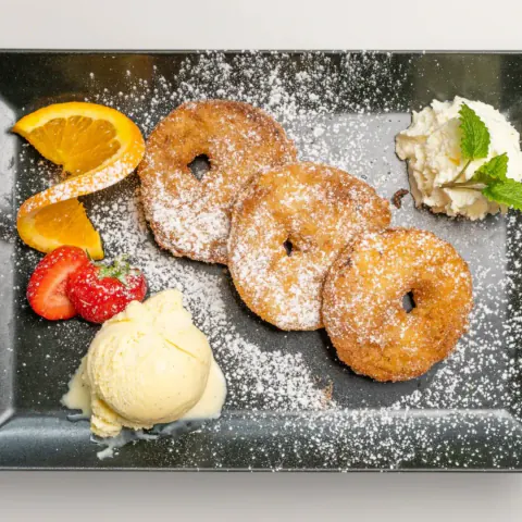 Apple fritters with vanilla ice cream and whipped cream