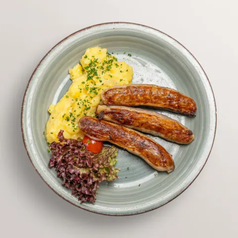 Three Franconian bratwurst sausages with homemade potato salad