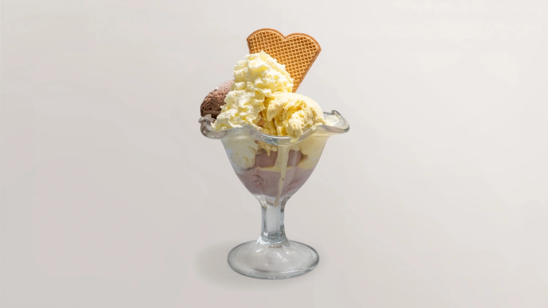 Gemischter Eisbecher mit Schokoladen- und Vanilleeis, Sahne und Waffelherz