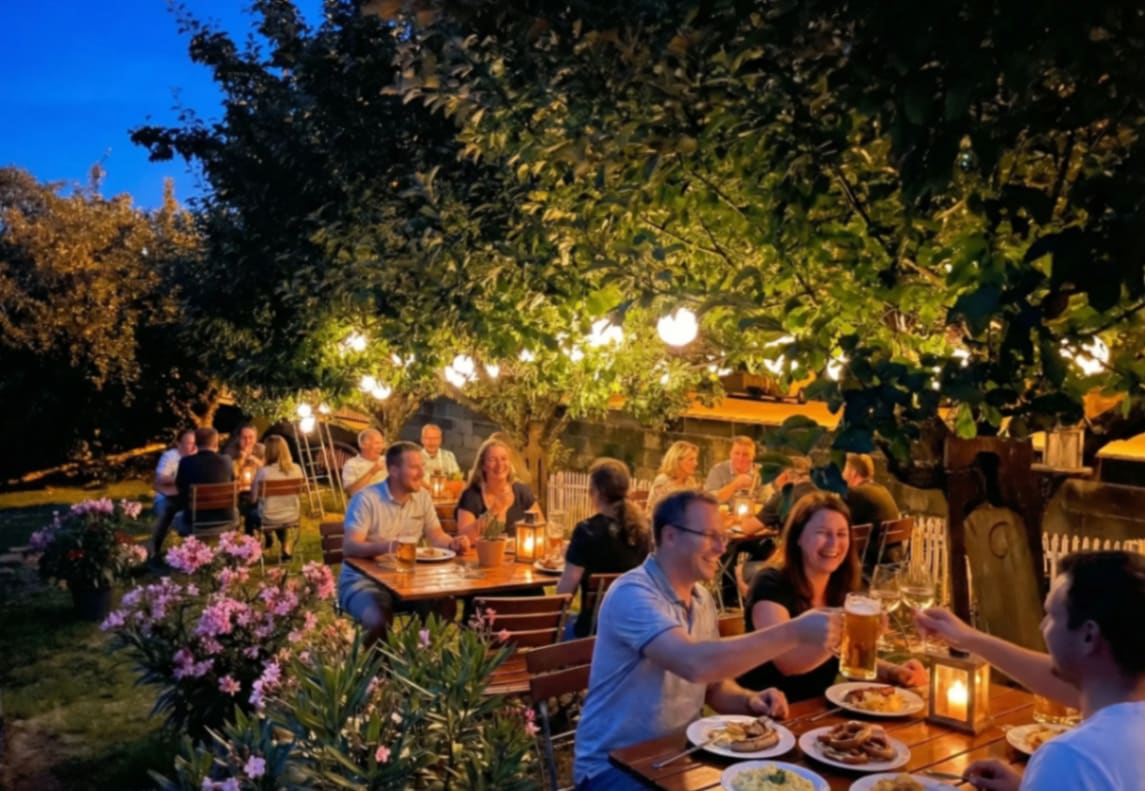 Biergarten an der Regnitz am Abend mit Lichterketten und Gästen