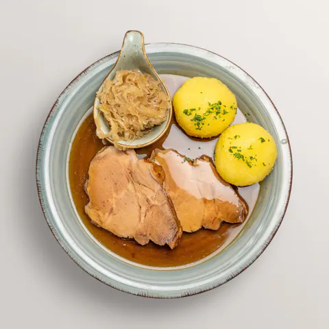 Franconian roast pork with potato dumplings, sauerkraut and dark gravy